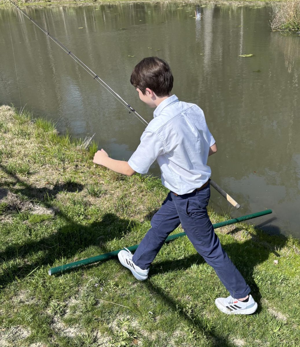 Middle school fishing club students in action near on campus ponds.